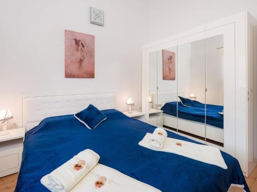 a bedroom with a blue bed with two towels at Villa Dea - Luxury Villa with Outdoor Swimming Pool in Vučevica