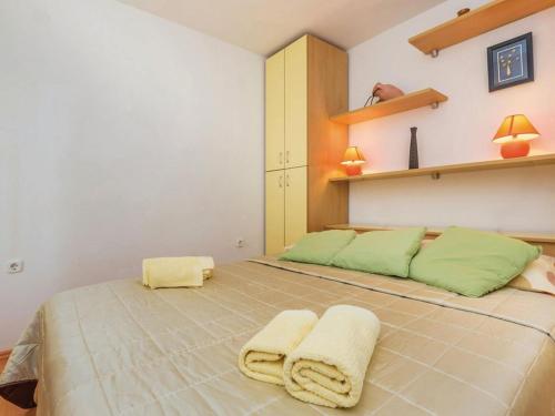 a bedroom with a large bed with two towels on it at Apartments Paola - Studio Apartment with Terrace and Sea View in Karlobag