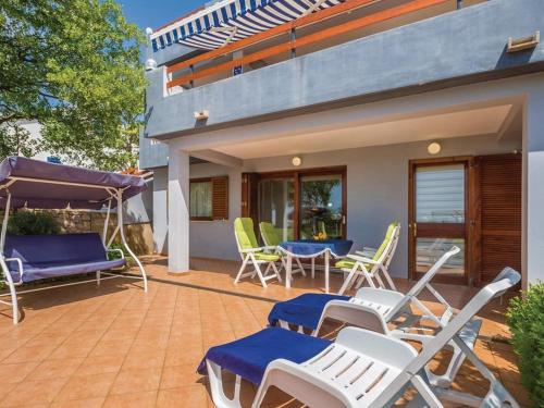 a patio with chairs and a table and chairs at Apartments Paola - Studio Apartment with Terrace and Sea View in Karlobag