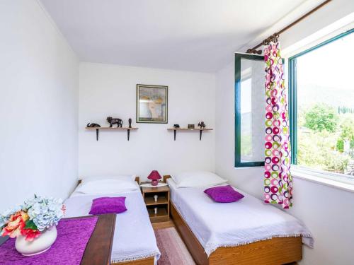 two beds in a room with a window at Apartment Laurel Leaf - Three Bedroom Apartment with Terrace in Gruda