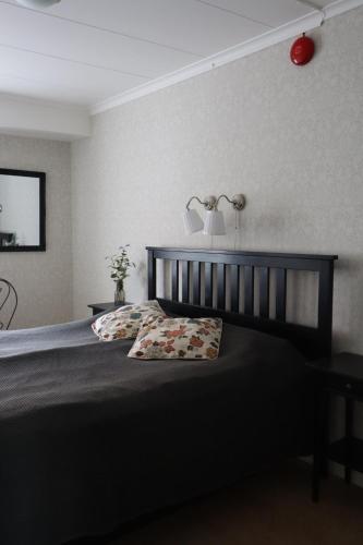 a bedroom with a bed with a lamp on the wall at STF Hostel Mariestad in Mariestad