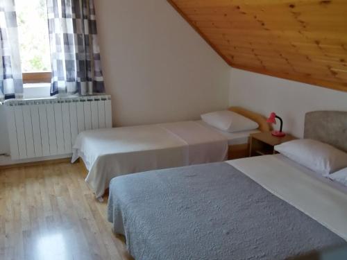 a room with two beds and a window at Guesthouse afran- Two Bedroom Apartment in Plitvička Jezera
