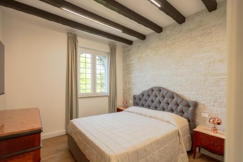 a bedroom with a bed and a brick wall at Villa Allegra Apartments in The Nature in Pozzolgroppo