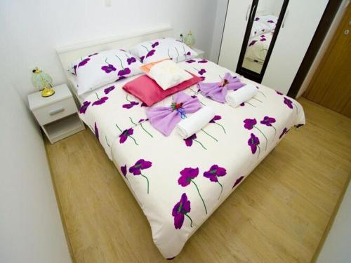 - une chambre avec un lit orné de fleurs violettes dans l'établissement Apartments Vesela - One Bedroom Apartment with Balcony and Sea View, à Janjina