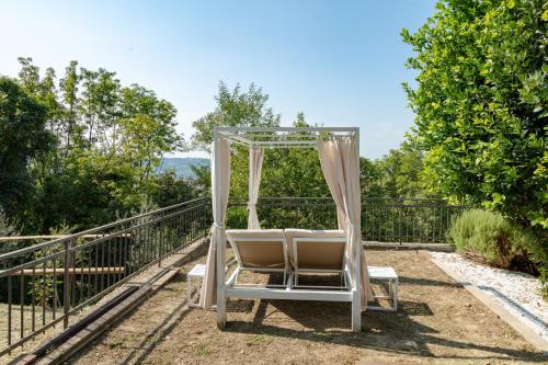 a white chair sitting on top of a iron fence at Villa Allegra Apartments in The Nature in Pozzolgroppo