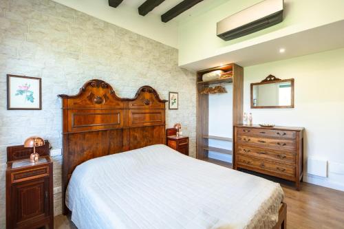 a bedroom with a large wooden bed and a dresser at Villa Allegra Apartments in The Nature in Pozzolgroppo