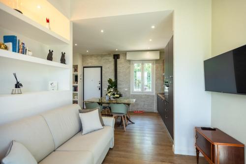 a living room with a white couch and a table at Villa Allegra Apartments in The Nature in Pozzolgroppo