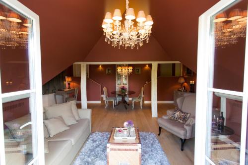 a living room with a couch and a chandelier at Villa Reynaert in Opoeteren