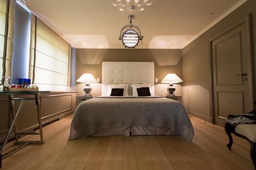 a bedroom with a bed and two lamps and a table at Villa Reynaert in Opoeteren