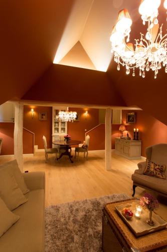 a living room with a couch and a chandelier at Villa Reynaert in Opoeteren