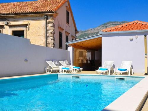 a swimming pool with chairs and a house at Holiday Home Belmondo- Three Bedroom Home with Terrace and Private Pool A6 in Gruda