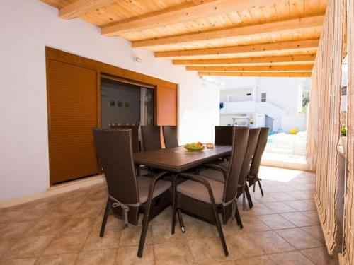 a dining room with a wooden table and chairs at Holiday Home Belmondo- Three Bedroom Home with Terrace and Private Pool A6 in Gruda