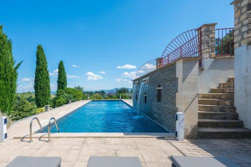 - une piscine à côté d'un bâtiment avec des escaliers dans l'établissement 30VENTSA Villa Mistral, à Saint-Ambroix