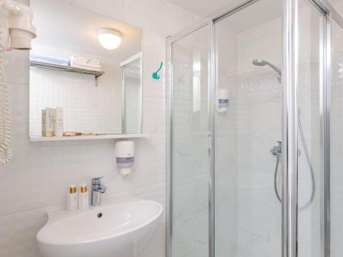 Un baño blanco con ducha y lavabo. en Apartments Villa Lukas - ''No 9'' Gallery Two Bedroom Apartment with Balcony and Sea View, en Cavtat