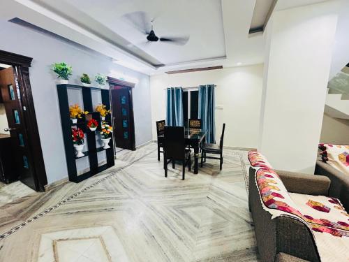 Una sala de estar con una mesa y un comedor. en Orion Studio Service Apartment, en Kondapur