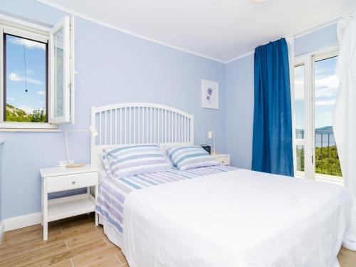 a white bedroom with a bed and a window at 3 Bedroom villa with terrace and pool in Zaton Doli