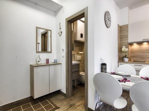 a kitchen and dining room with white chairs and a table at Apartments Victoria - One Bedroom Apartment with Terrace A2 in Pakoštane
