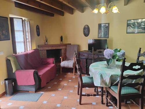 una sala de estar con una mesa y sillas en Casa Rural Casa Azul, en Villahormes