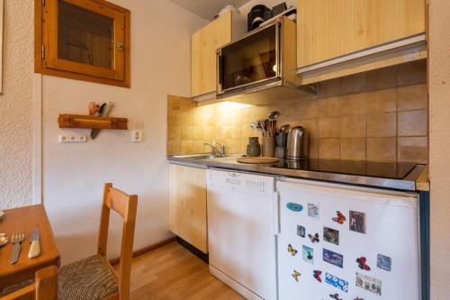une cuisine avec un réfrigérateur blanc et un évier dans l'établissement Large duplex in Méribel Village with balcony, à Les Allues