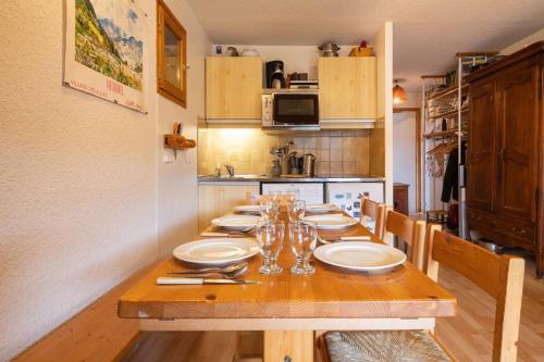 une cuisine avec une table en bois et des plaques de cuisson. dans l'établissement Large duplex in Méribel Village with balcony, à Les Allues