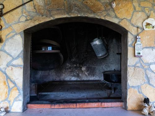a stone fireplace with a stove in a stone wall at Apartments Belenum - Comfort Double Room with Balcony and Sea View no 1 in Mlini