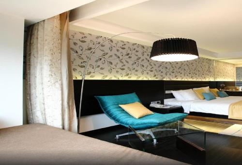 a bedroom with a bed and a blue chair at Country Inn & Suites By Radisson, Bengaluru Hebbal Road in Bengaluru