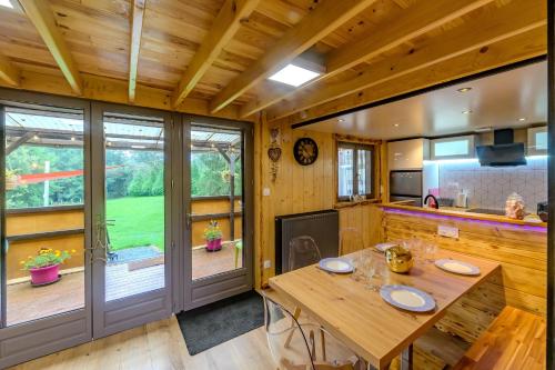 Il comprend une cuisine et une salle à manger avec une table en bois. dans l'établissement Rêves au Chalet - Maisonnette avec jacuzzi, à Floyon