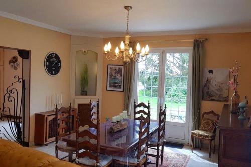 ein Esszimmer mit Glastisch und Stühlen in der Unterkunft Gîte La Châtelaine 4 Épis in Les Molières