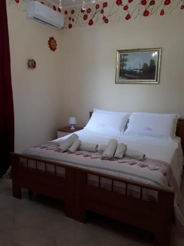 a bed in a bedroom with a picture on the wall at PerlaVerde in Patti
