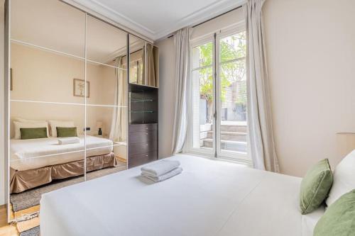 une chambre avec un grand lit blanc et une fenêtre dans l'établissement Hôtel particulier dans le 17ème arondissement, à Paris
