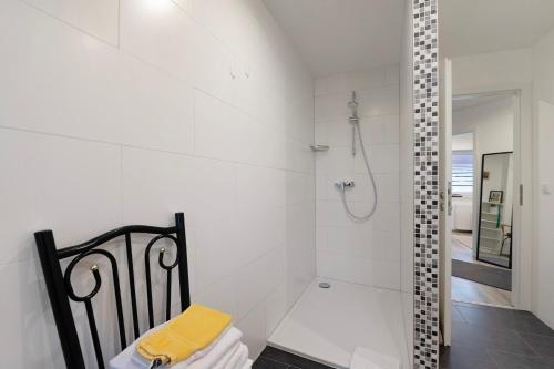 a white bathroom with a shower with a glass door at Fewo Weber in Sankt Ingbert