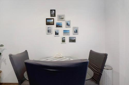 a table with chairs and pictures on a wall at Fewo Weber in Sankt Ingbert