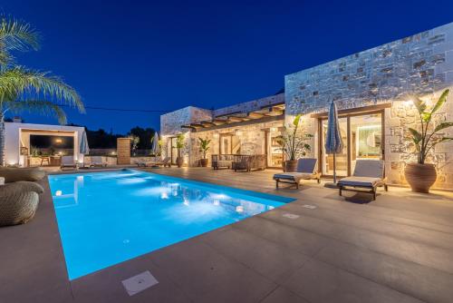 a swimming pool in front of a house at White Stone Villa Orion - Poolside Escape Close to Laganas Beach in Lithakia