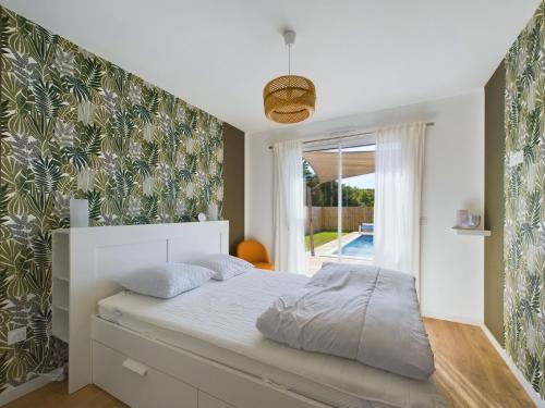 a bedroom with a bed and a large window at Maison pour 6 adultes avec piscine in Notre-Dame-de-Riez