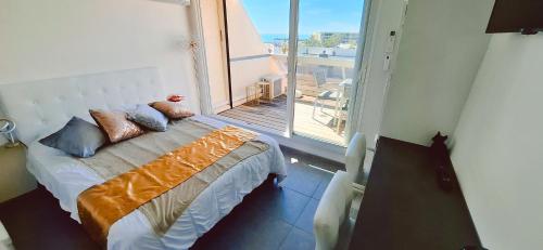 un lit dans une chambre avec une grande fenêtre dans l'établissement Village naturiste Cap d'Agde le Cap Pleasure, au Cap d'Agde