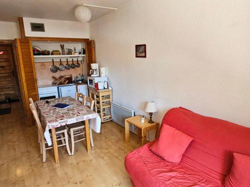 un salon avec un canapé rouge et une table dans l'établissement Charmant Studio Cabine 4 Pers, Exposé Sud, Balcon, Piscine, Parking, Proche Pistes et Commerces - FR-1-263-144, à Valloire