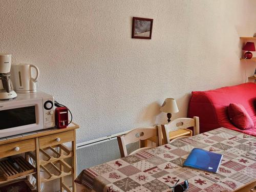 Cette petite chambre comprend un lit et un four micro-ondes. dans l'établissement Charmant Studio Cabine 4 Pers, Exposé Sud, Balcon, Piscine, Parking, Proche Pistes et Commerces - FR-1-263-144, à Valloire