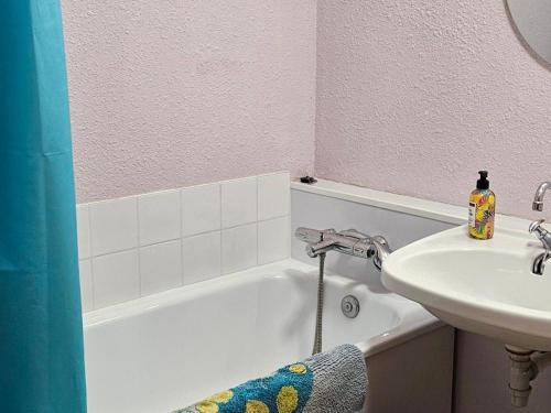 La salle de bains est pourvue d'un lavabo et d'une baignoire blanche. dans l'établissement Charmant Studio Cabine 4 Pers, Exposé Sud, Balcon, Piscine, Parking, Proche Pistes et Commerces - FR-1-263-144, à Valloire