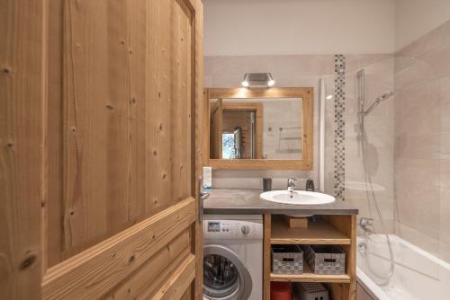 a bathroom with a sink and a washing machine at Appartement Samoëns in Samoëns