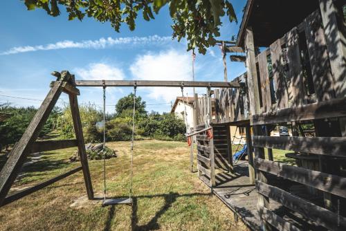 an old swing in front of a house at Maison Galine - Piscine & Aire de Jeux - Maison de campagne in Beauvais-sur-Tescou