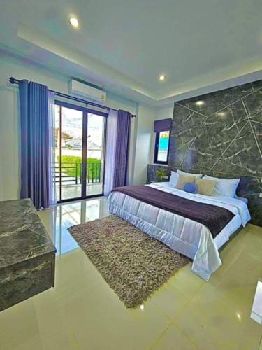 a bedroom with a large bed and a large window at Mana Pool Villa in Ban Huai Yai