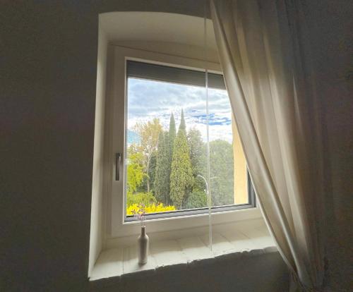 a window with a view of a garden outside at The Lake Suites com - Luxury stay in Lazise in Lazise