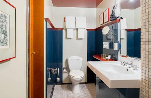 a bathroom with a white toilet and a sink at Domicil Hotel Bonn in Bonn