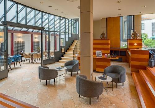 a lobby of a building with chairs and tables at Domicil Hotel Bonn in Bonn