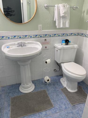 a bathroom with a sink and a toilet and a mirror at Pirates Pointe Resort in Ruskin