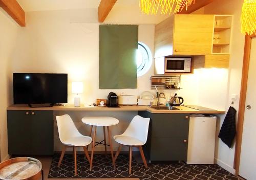 une cuisine avec un comptoir avec deux chaises et une table dans l'établissement VILLA VOLTAIRE, à Clamart