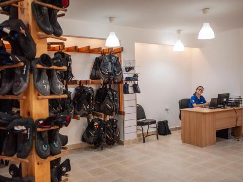 a woman sitting at a desk in a room with shoes at Blue Vision Diving Hotel in Marsa Alam City