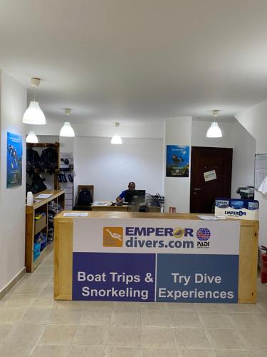 an office with a desk with a sign on it at Blue Vision Diving Hotel in Marsa Alam City