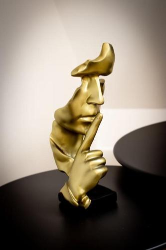 a gold figurine of a man holding his hand up at Le Donjon Secret in Caen