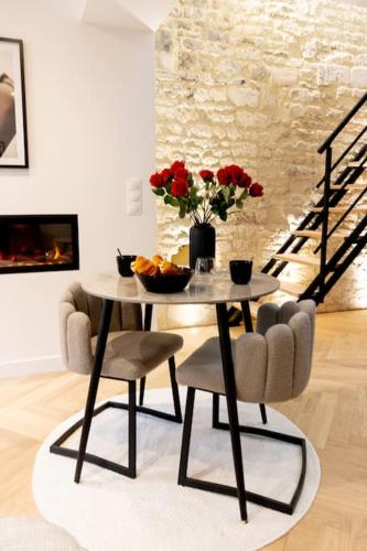 a table and chairs with a vase of flowers on it at Le Donjon Secret in Caen